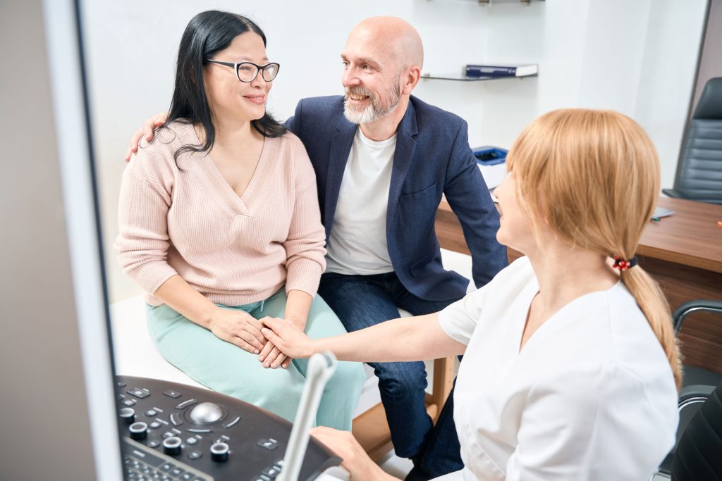 Woman with her husband OBBYN checkup.