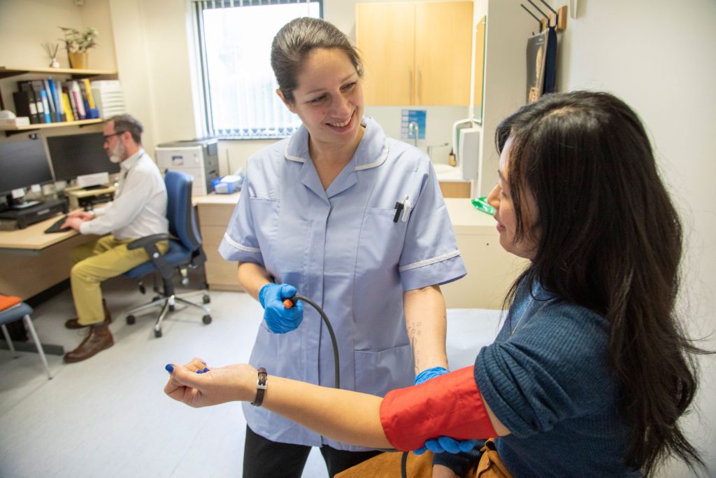 Nurse taking patient's blood pressure.