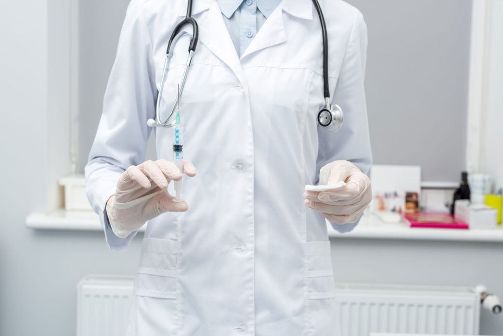 Female doctor holding a syringe.