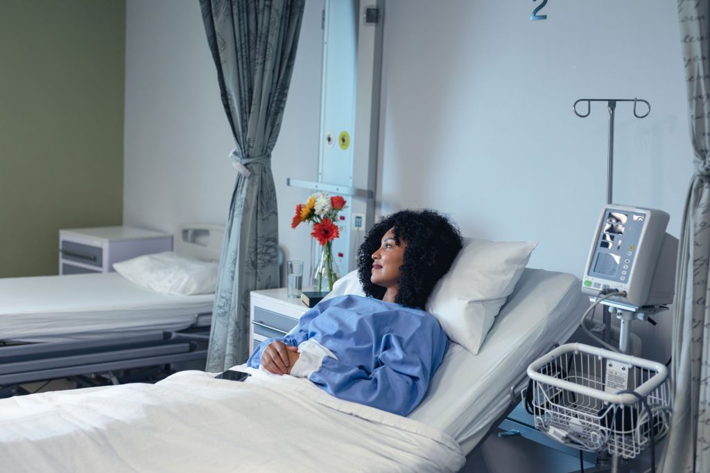 Patient lying in hospital bed post-operation.