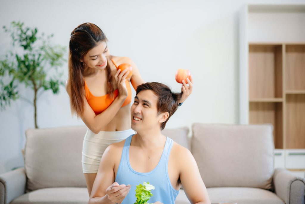 Fit couple preparing healthy food at home.