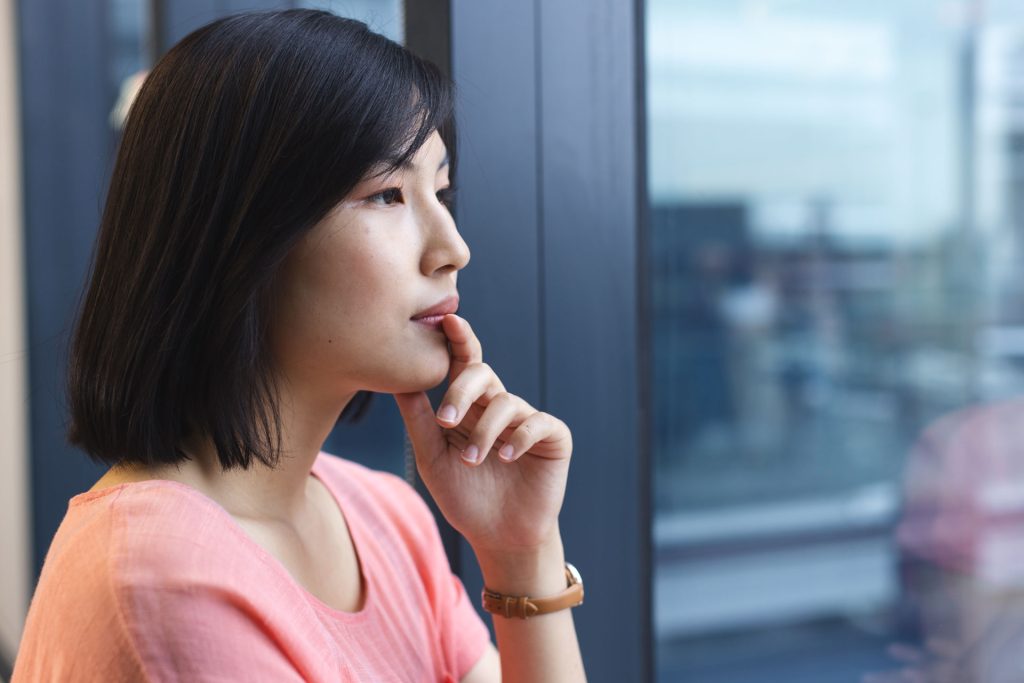 Asian woman looking out the window.