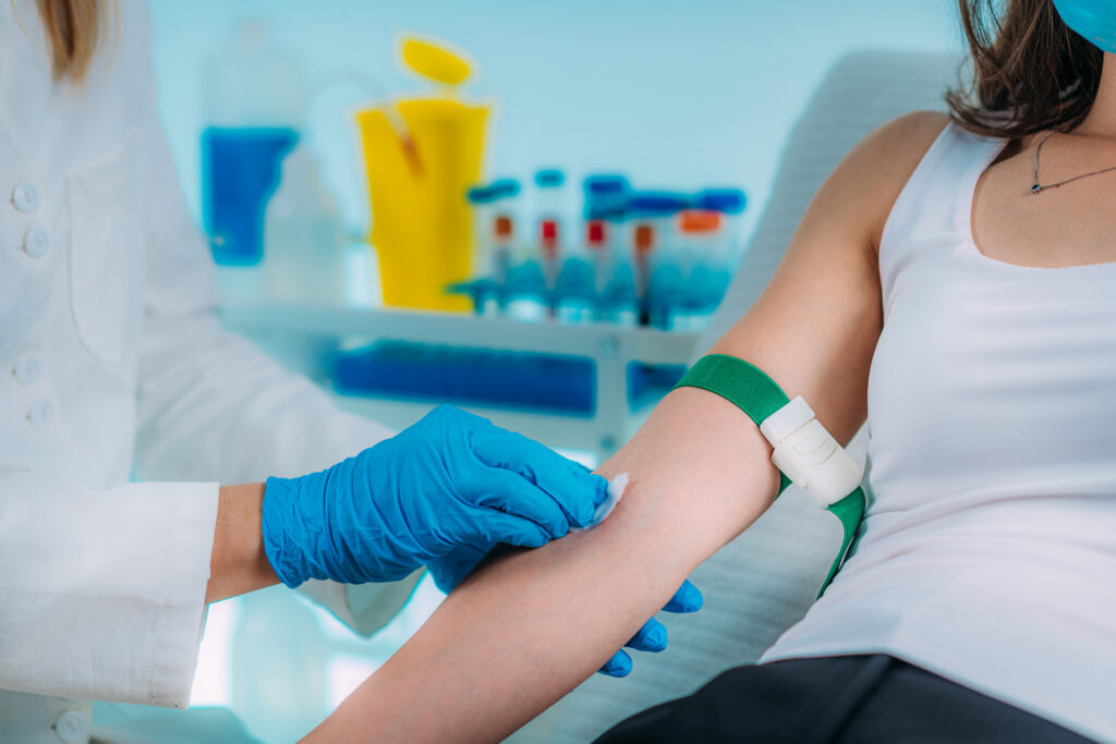 Medical Worker with PPE taking blood sample.
